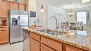 Una cocina con encimeras de granito, electrodomésticos de acero inoxidable y armarios de madera.
