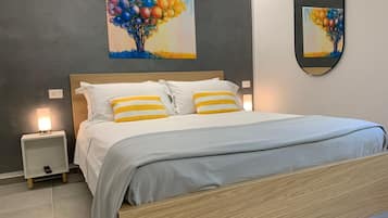 Une chambre à coucher moderne, avec un lit, des tables de chevet et un miroir fixé au mur.