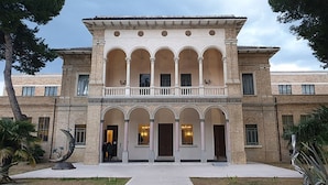 A building with a central courtyard, multiple arches, and a balcony. - Casa Armonia Sulmona Apartment (Sulmona)