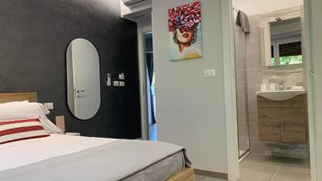Ein modernes Schlafzimmer mit einem Bett, einem großen Spiegel und einem Gemälde an der Wand.