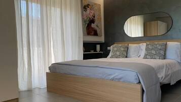 Un dormitorio moderno con una cama de madera, un espejo grande y un cuadro en la pared.