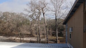 A wooden building with a metal roof, surrounded by trees and a clear sky. - Cozy hotel suite in peaceful Mayo with AC, WiFi, fitness room (Mayo)