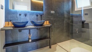 A modern bathroom with two vessel sinks, a large mirror, and a glass shower enclosure. - Blue Suite by Hello Homes Sitges (Sitges)