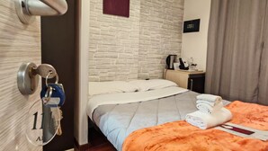Une chambre d’hôtel équipée d’un lit, d’un bureau, d’un appareil de climatisation et d’une porte à clé.