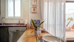 A kitchen with a wooden countertop, a sink, and a window. There are framed pictures on the wall and a plant on the counter. - Central Terrace by Hello Homes Sitges (Sitges)