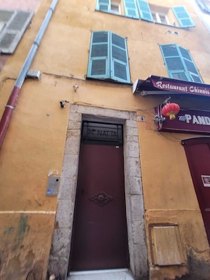 Traditional building with a historic entrance featuring a dark brown door and a sign for Restaurant Chinois.