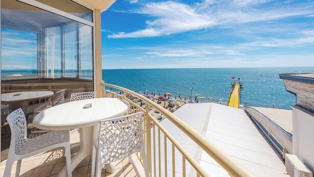 A balcony with a view of the sea, white outdoor furniture, and a yellow lifebuoy. - Aragosta Hotel (Durrës)