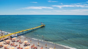 Privatstrand, weißer Sandstrand, Sonnenschirme, Strandtücher