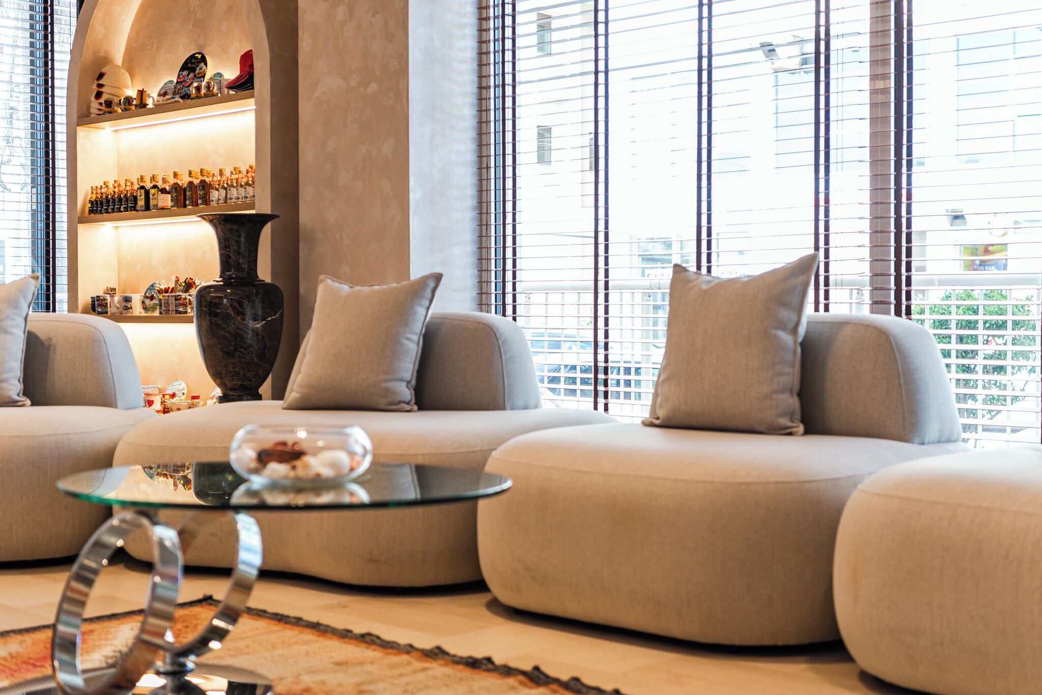 A modern living room with a sofa set, a glass coffee table, and a decorative vase.