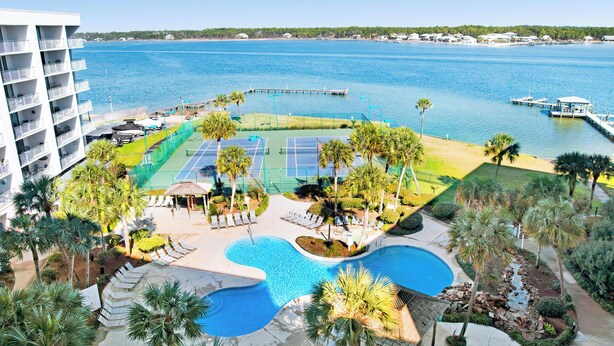 Un complexe hôtelier doté d’une piscine, de courts de tennis et offrant une vue sur la mer.