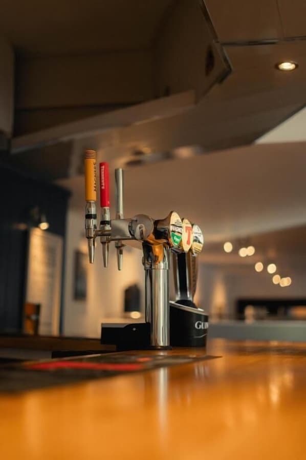A tap system with multiple beer taps and a tap handle labeled "GLU".