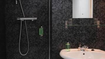 Une salle de bain moderne équipée d’une baignoire, d’une douche, d’un lavabo et d’un miroir.