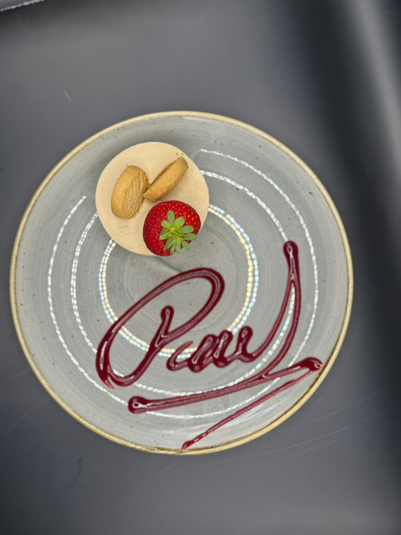 Un plato de postre con fresa y almendras, y la palabra 'Pear' escrita en él.