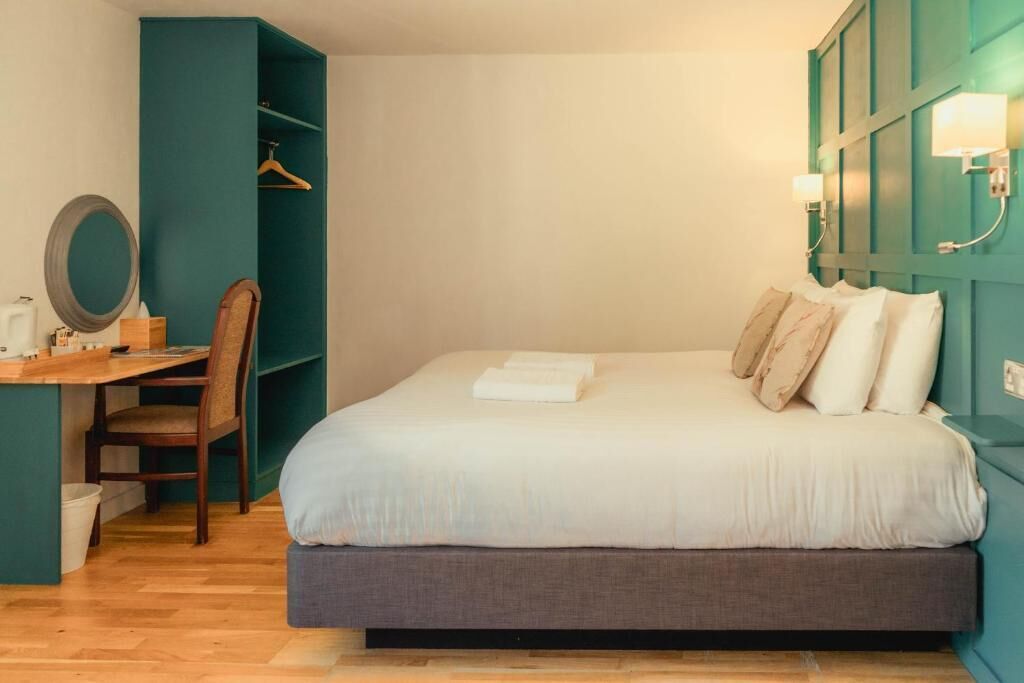 Une chambre à coucher avec un lit, un bureau et une chaise.