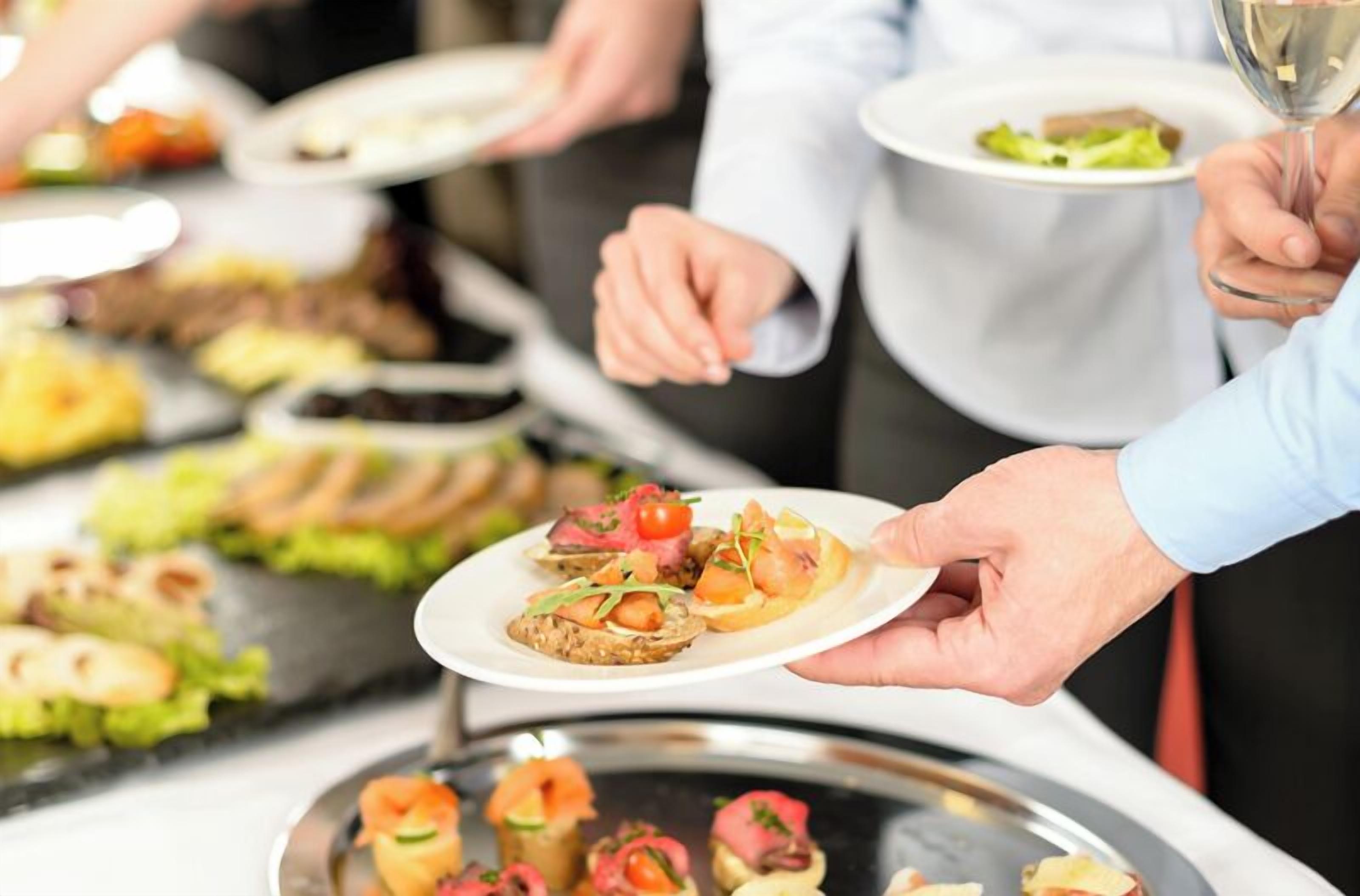 En buffet med forskellige retter og en person der serverer mad.
