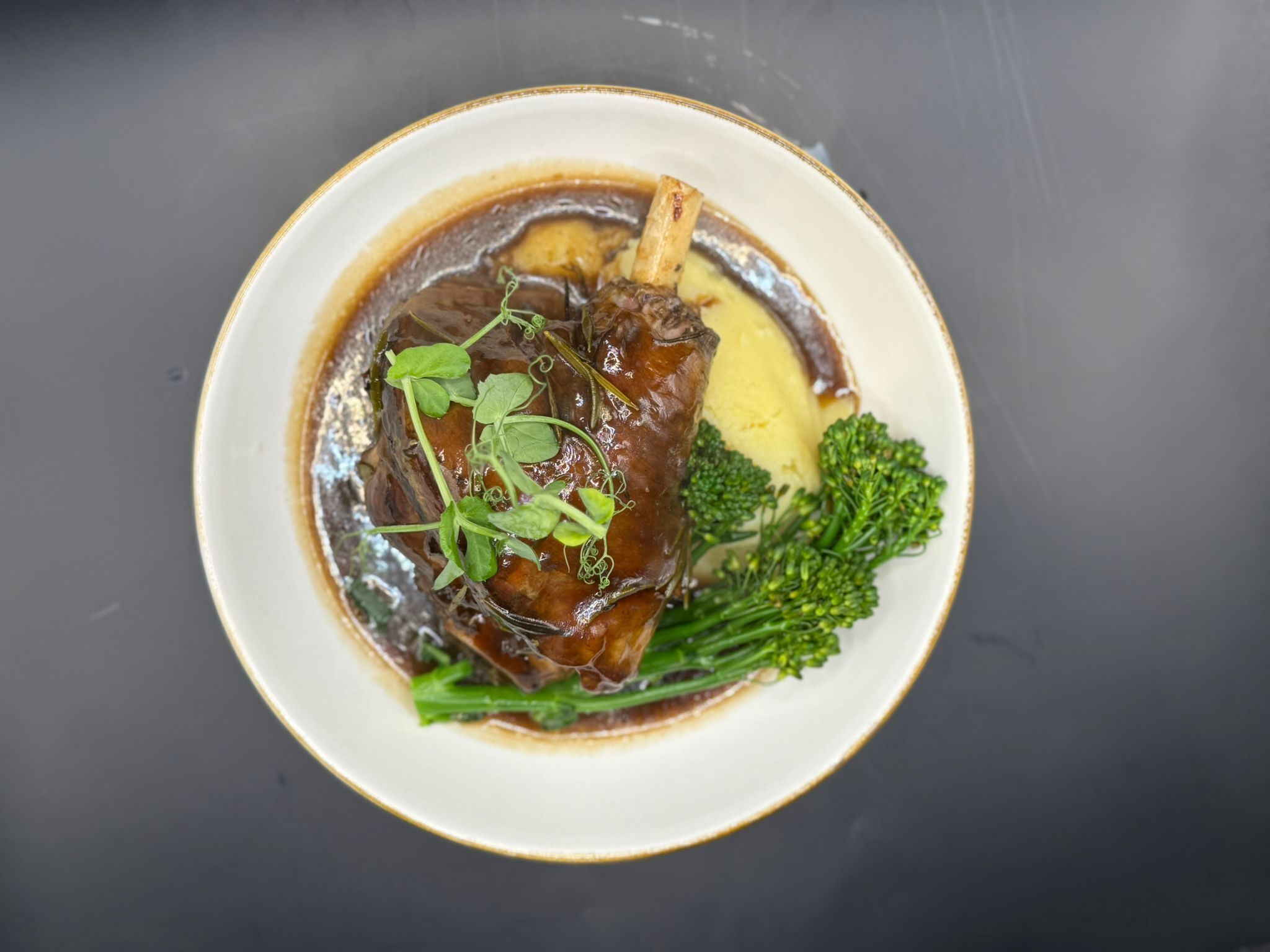 Um prato com carne, brócolis e molho.