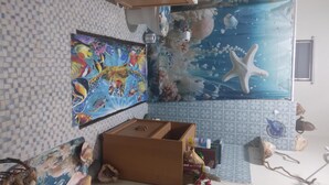 A room with a tiled floor, a large mural of sea creatures, a wooden cabinet, and various decorative items. - 212A-HOUSE TENT & GET 60-10 = 50 BIOBAY TOUR TEXT 787 614-5678 DATE-NAMES-EMAIL (Esperanza)