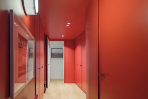 A hallway with red walls and a framed picture on the wall. - Paris St Germain Loft Residence (Paris)