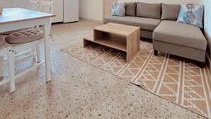 Um espaço de estar moderno com cozinha, área de refeições e um conjunto de sofás.