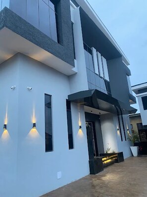 A modern building with a flat roof, large windows, and a symmetrical facade. - C33 Apartment And Suites  (Enugu)
