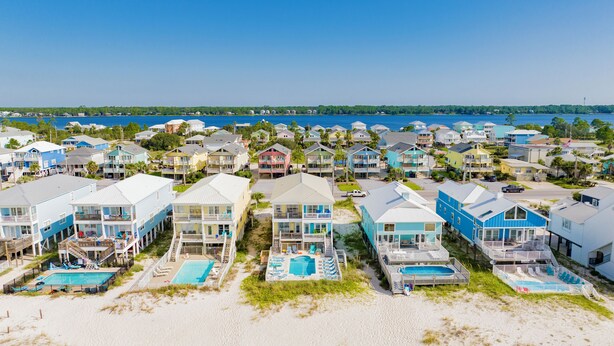 A beachfront residential area with houses featuring balconies and swimming pools. - Gulf Front Duplex | Shared Pool | West Beach (Gulf Shores)