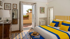 A bedroom with a bed, bedside table, lamp, and a view of the outside balcony. - Villa Maelle by My Villa Collection (Positano)