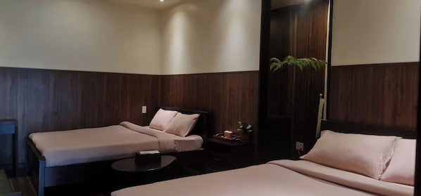 A hotel room with two single beds, a small round table, and a plant. - Pha Boutique House (Xuan Huong - Da Lat)