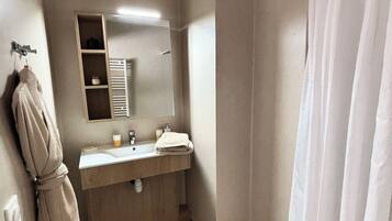 A bathroom with a wooden vanity, a towel rack, a mirror, and a shower curtain.