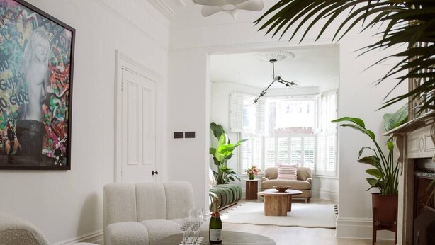 A living room with a sofa, a coffee table with a bottle and glasses, and a painting on the wall. - Luxury 5-Bedroom, Central London Town House (Greater London)