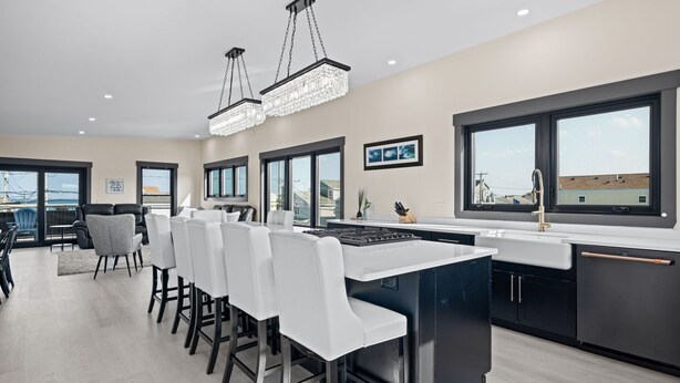 A modern kitchen with a central island, bar stools, and large windows. - Easy Beach Access, Sleeps 12 (Old Orchard Beach)