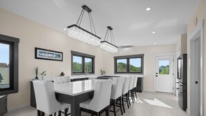A modern kitchen with a large island, pendant lighting, and a view of the outdoors. - Easy Beach Access, Sleeps 12 (Old Orchard Beach)