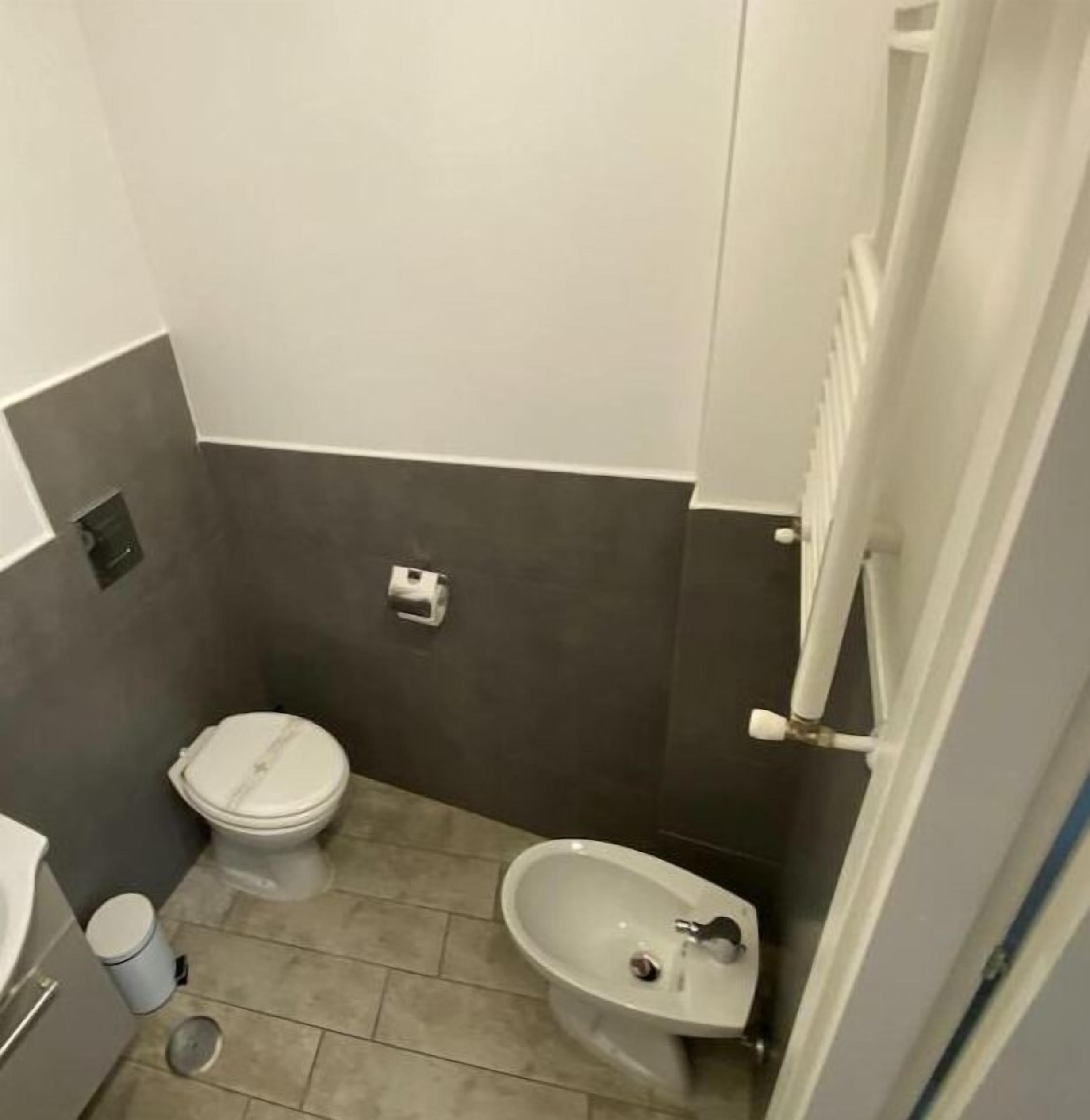 A small bathroom with a toilet, bidet, and sink.
