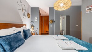 A hotel room with a bed, pillows, a bedside table, a lamp, and a wall with motivational quotes. - FLH Funchal Sissi Lanço with View (Funchal)