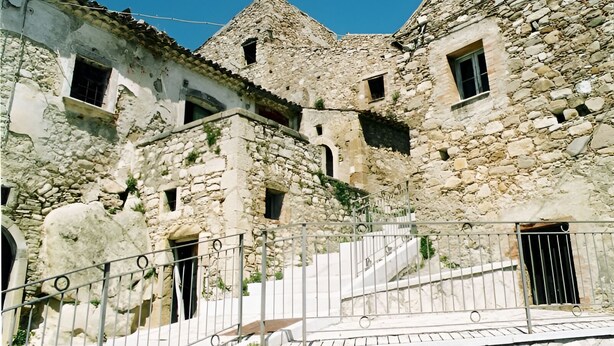 A stone building with multiple windows and a staircase leading to an upper level. - Guest House " La Corte" Green Orchid. An oasis of serenity and refinement. (Zungoli)