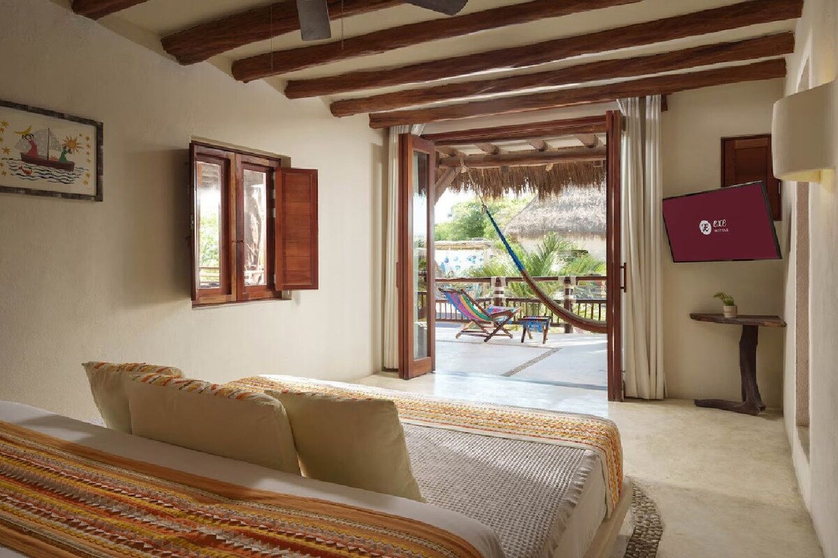 Un dormitorio con cama, ventana y vistas al exterior.