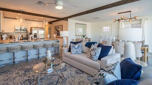 A modern kitchen with a bar area, a living room with a sofa and chairs, and a dining area with a table and chairs. - Scottsdale Heated Pool Sleeps 20, Gorgeous! Near Old Town (Scottsdale)