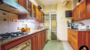 Una cocina con armarios de madera, una estufa a gas y un microondas.