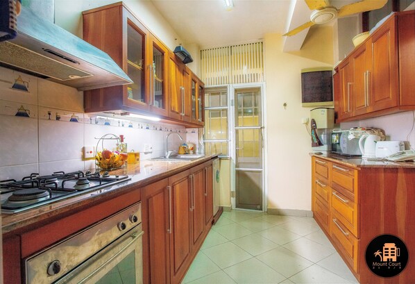 A kitchen with wooden cabinets, a gas stove, and a microwave.