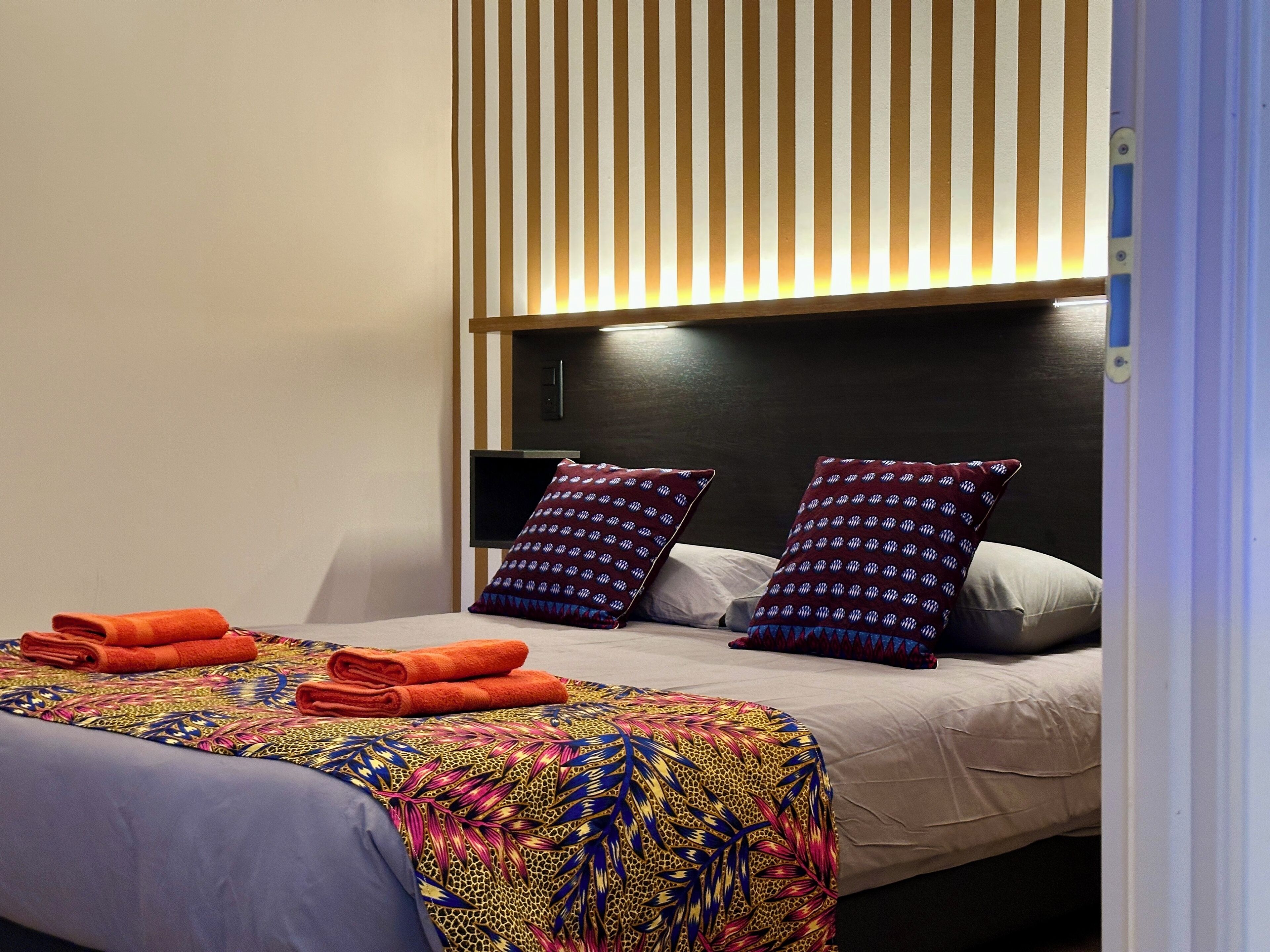 Una habitación de hotel con cama, almohadas y una toalla doblada.