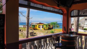 A balcony with a view of the sea and colorful buildings. - Paradise on the Rocks - Suite w/Kitchenette #9 (Negril)