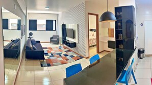 Una sala moderna con sofá, televisor y alfombra estampada.