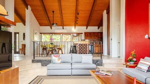A modern living room with a grey sofa, wooden coffee table, and a red accent wall.