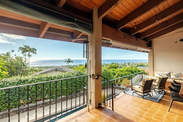 A balcony with a view of the ocean and palm trees. - Luxury Home w/Pool, King Suites & Sunset Views (Kailua-Kona)