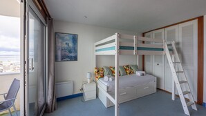 A bunk bed with a ladder, a bedside table with a lamp, a chair, and a painting on the wall. - Horizon Bleu - Superbe vue sur le port (Arcachon)