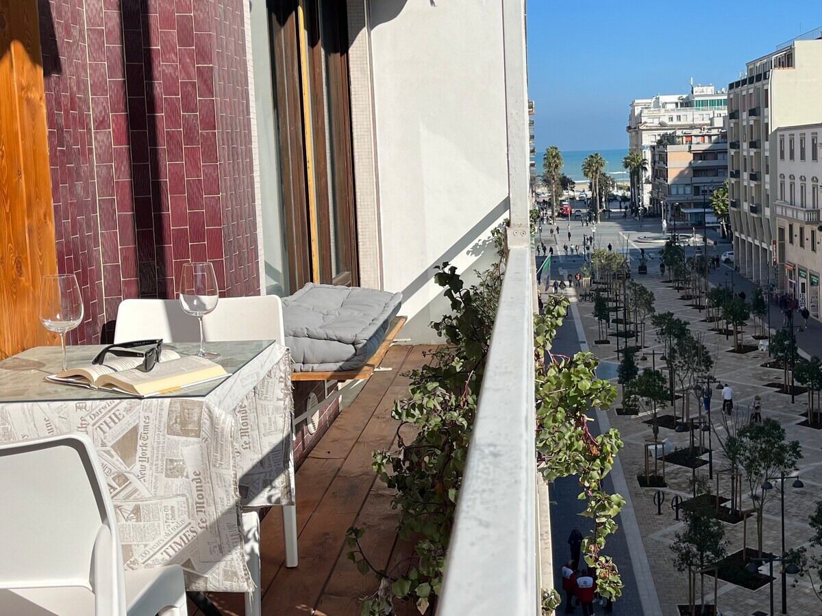 Un balcone con vista su una strada cittadina e una spiaggia.