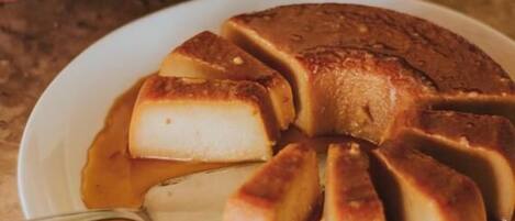 A caramel flan on a plate with a spoon.
