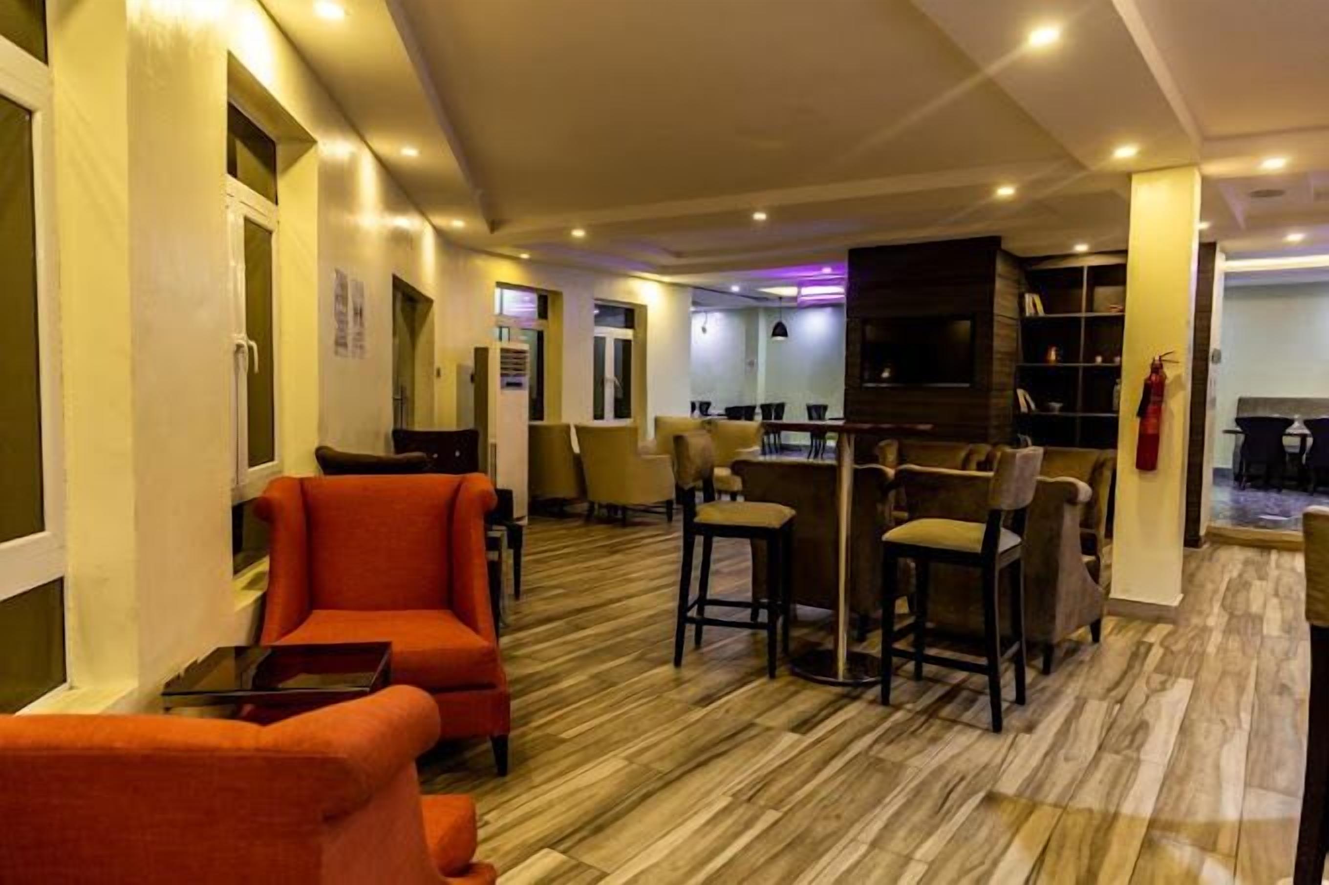 Vestíbulo de hotel con zona de bar, asientos y extintor.