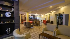 A modern hotel lobby with a bar area, seating arrangements, and a bookshelf. - Dee Rocket Hotel (Ibadan)