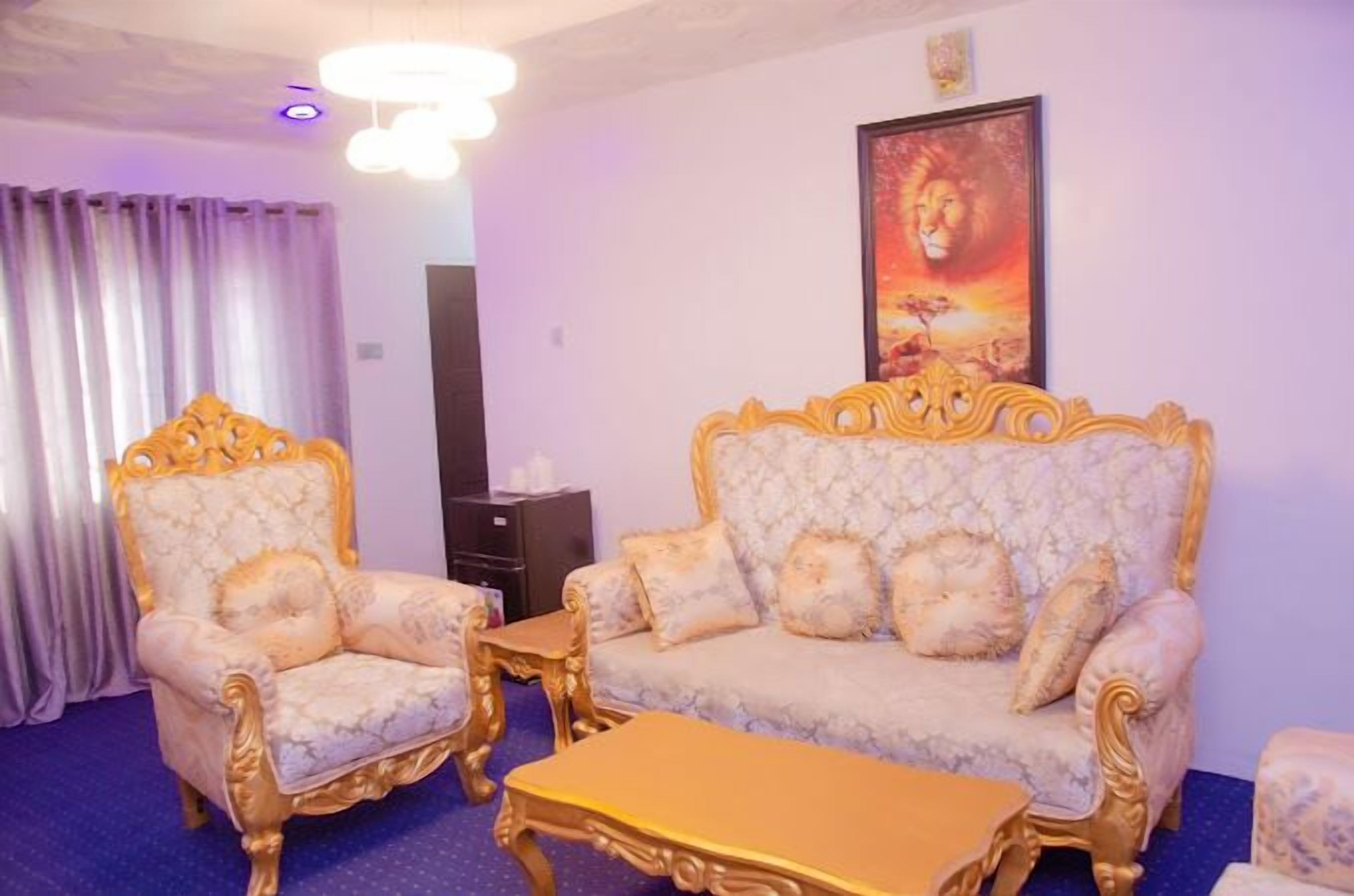 Um quarto com sofá, duas poltronas e mesa de centro.