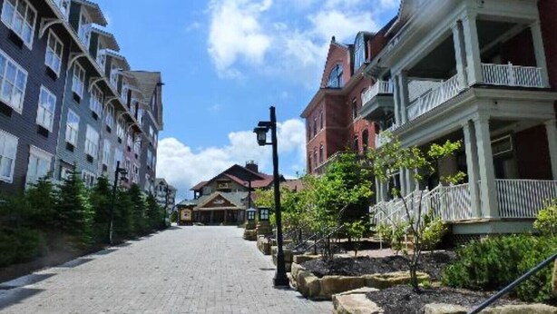 A cobblestone street lined with multi-story buildings, some with balconies and a mix of architectural styles. - NEW! Seneca 113: Private Entrance, Hot Tub, Heated Garage, Sleeps 6! (Snowshoe)